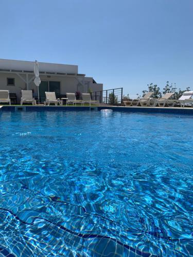 a large swimming pool with blue water at Casa Branca in Tavira