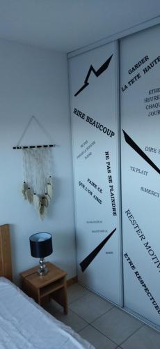 a room with a bed and a wall with signs at Le Repaire du Golfeur de la Largue - Mooslargue in Mooslargue