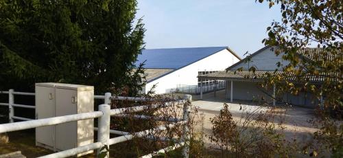 a white building with a fence and a house at Le Repaire du Golfeur de la Largue - Mooslargue in Mooslargue