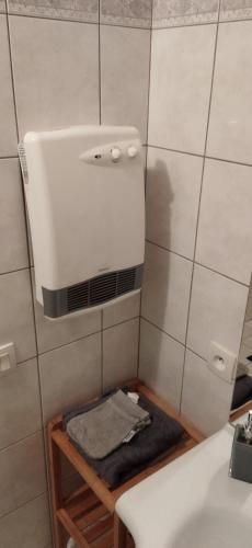 a bathroom with a towel on a shelf next to a sink at Le Repaire du Golfeur de la Largue - Mooslargue in Mooslargue