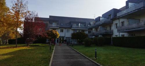 an apartment building with a sidewalk in front of it at Le Repaire du Golfeur de la Largue - Mooslargue in Mooslargue