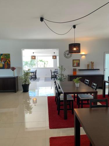 a dining room with tables and chairs and a red rug at Casa Branca in Tavira