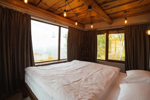 ein Schlafzimmer mit einem großen Bett und einem großen Fenster in der Unterkunft Hygge House in Vyshka