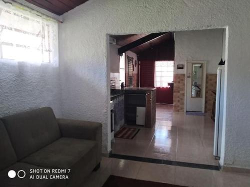 a living room with a couch and a kitchen at Casinha Aconchegante no 3° Melhor Clima do Mundo. in Miguel Pereira