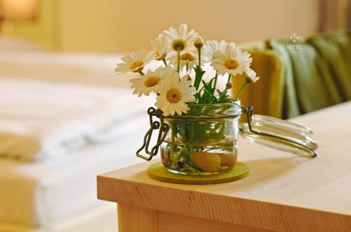 a jar with flowers in it sitting on a table at Hotel B&B "Zur Schanz" in Ebbs
