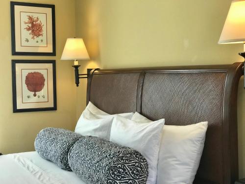 a bedroom with a bed with white pillows and two pictures at West Cliff Inn, A Four Sisters Inn in Santa Cruz