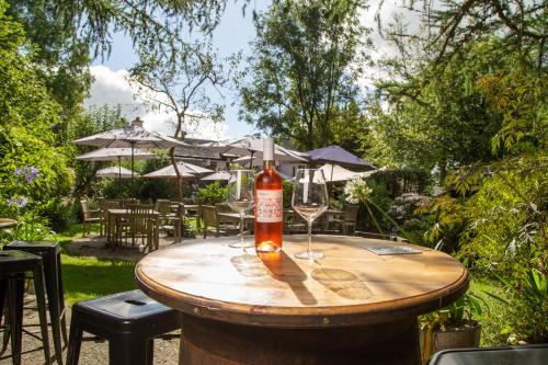 a bottle of wine sitting on a wooden table with glasses at Castle Inn in Lydford