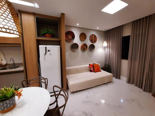 um quarto com uma cama, uma mesa e um frigorífico em Guarajuba Summer Flat Melhor localização de Guarajuba e melhores Flats Beira Mar de Guarajuba Dispomos de 4 flats decorados no mesmo condomínio Aqui você não precisa de carro para nada Faça tudo à pé em Guarajuba