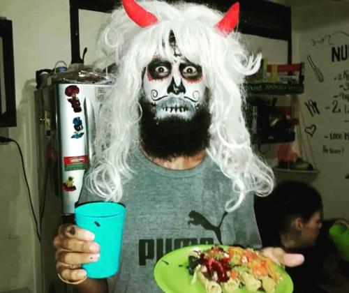 a man dressed in a skeleton costume with a plate of food at Casa Apapacho hostel in San Cristóbal de Las Casas