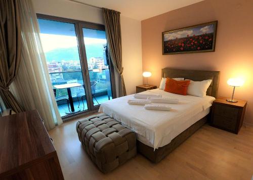een slaapkamer met een groot bed en een groot raam bij Diva Capitol Luxury in Skopje