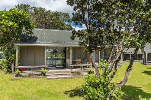 a house with a picnic table in a yard at Camp Waipu Cove in Waipu