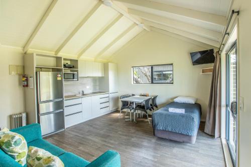 a kitchen and dining room with a table and chairs at Camp Waipu Cove in Waipu