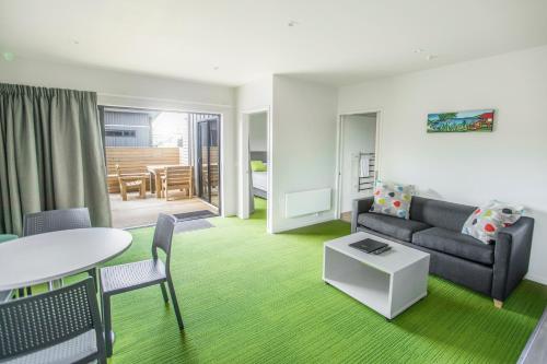 a living room with a couch and a table at Camp Waipu Cove in Waipu