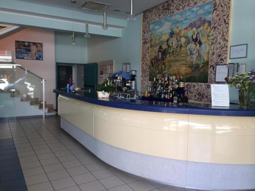 a bar in a restaurant with a painting on the wall at Hotel Sultano in Rimini