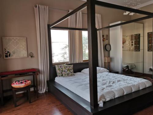 a bedroom with a four poster bed with a window at Daffodils in Ajman 