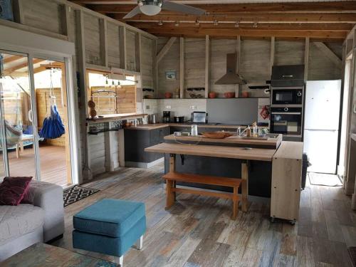 een keuken met een grote houten tafel in een kamer bij ZENALIZES bungalow calme et confortable in Le Moule