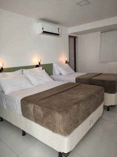 two beds in a hotel room with two bedsvisor at Rede Suítes in Maragogi