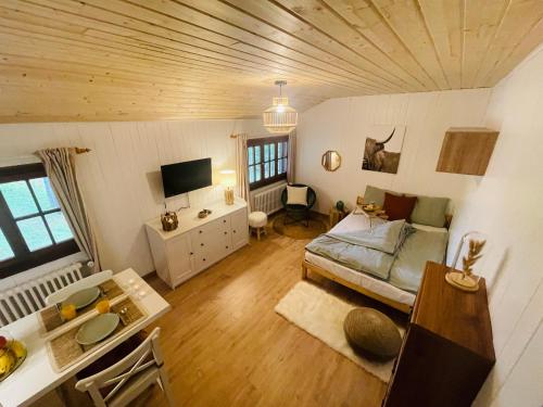 ein Wohnzimmer mit einem Bett und einem Tisch in der Unterkunft Serpolet - Studio - Sauna in Leysin