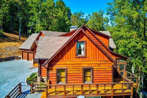 a wooden cabin with a porch in the woods at Talking Creek Lodge in Talking Rock