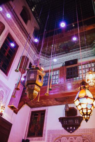 a room with hanging lights and chandeliers in a building at Riad Verus in Fès