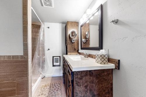 a bathroom with a sink and a mirror and a shower at Glacier & Ducks Unlimited in Big Sky
