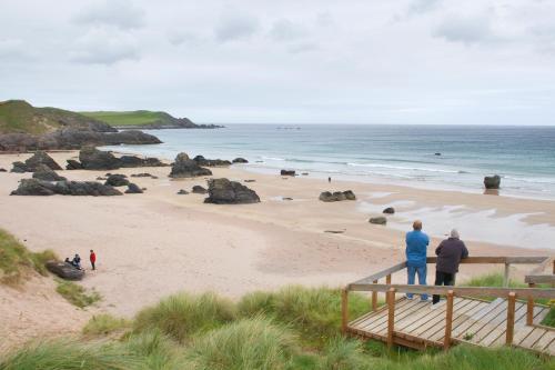 a group of people standing on a beach at Durness Youth Hostel in Durness