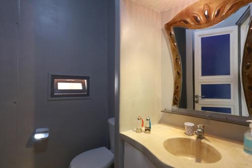 Diamant La Ville Rouge في مراكش: حمام مع حوض ومرآة ومرحاض