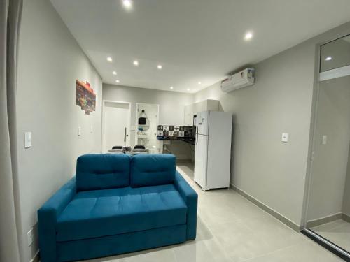 a blue couch in a living room with a refrigerator at Waikiki Apartament Ipanema in Rio de Janeiro