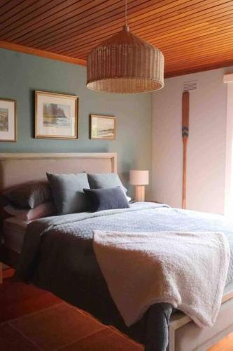 a bedroom with a bed and a wooden ceiling at Lylah’s By The Sea in Wynyard