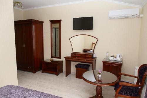 a living room with a table and a mirror at Prima Villa Guest House in Vinnytsya
