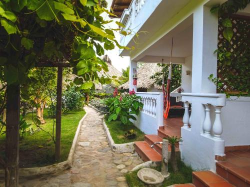 a house with a stone walkway leading to the front yard at Primaluna Beach Hostel in Palomino