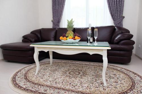 a coffee table with a bowl of fruit on top of a couch at Prima Villa Guest House in Vinnytsya