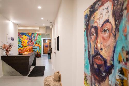 - un couloir orné de peintures colorées sur les murs dans l'établissement Hotel Des Arts, à San Francisco