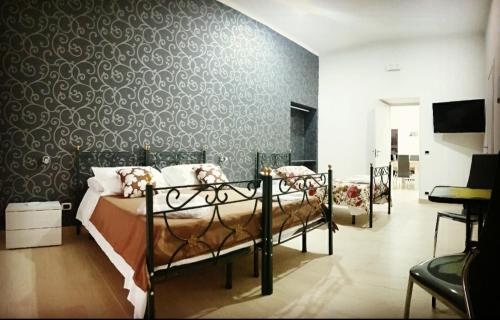 una camera con due letti in una stanza con un muro di La Residenza Della Fenice a Castellammare di Stabia