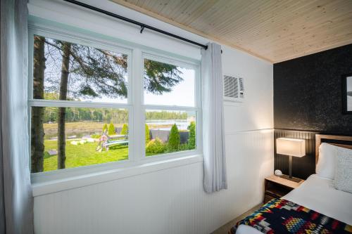 a bedroom with a window with a view of a yard at Placid Bay Hotel in Lake Placid