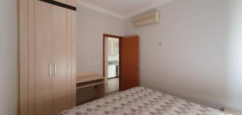 um pequeno quarto com uma cama e um closet em APARTAMENTO ÁGUAS DA SERRA - 005b em Rio Quente