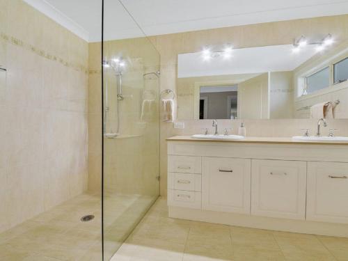 a bathroom with two sinks and a glass shower at Camelot in Bowral
