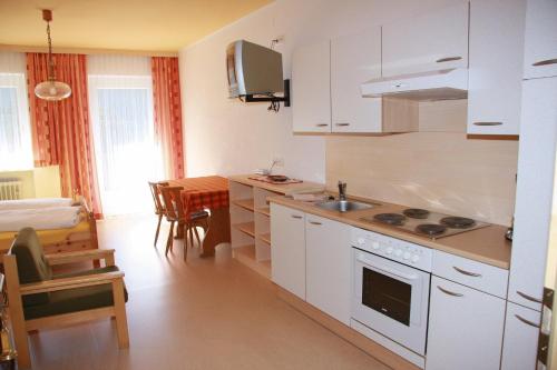 a kitchen with a sink and a stove top oven at Appartementhaus Sabine in Obertilliach