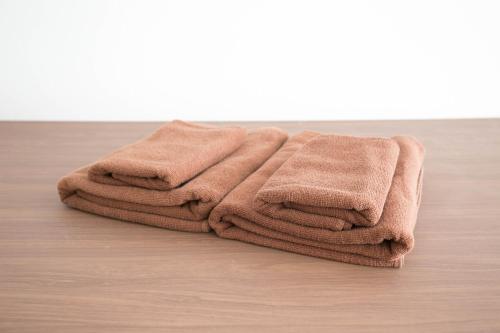 a pile of brown towels sitting on a wooden floor at Minoshima Apartment 402 in Fukuoka