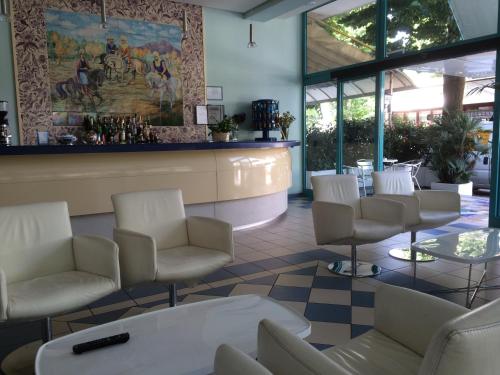 a waiting room with white chairs and a counter at Hotel Sultano in Rimini