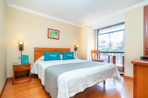 um quarto com uma cama grande e almofadas azuis em Ayenda La Antigua em Tunja