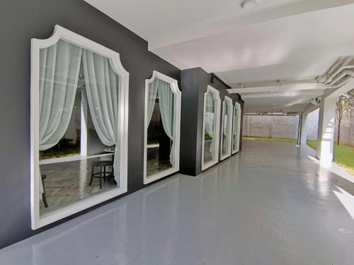 a hallway with a row of paintings on the wall at The Lantern Hatyai Hotel in Hat Yai