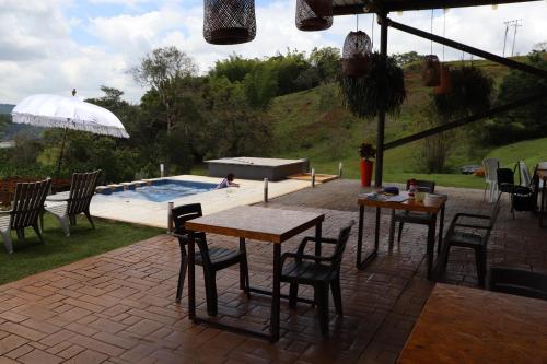 a patio with tables and chairs and a swimming pool at ADAMA BIOHOTEL in Calima