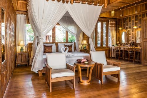 納泰海灘的住宿－Santhiya Phuket Natai Resort & Spa，卧室配有一张床和一张桌子及椅子