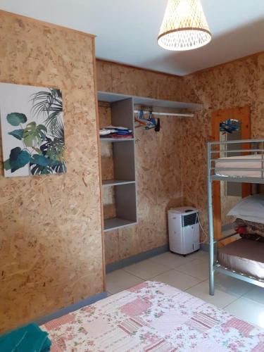 a room with a bunk bed and a shelf at Ti Kaban Letchi in Le Tampon