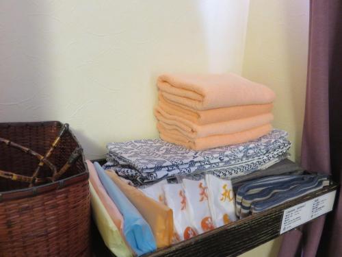 a pile of towels are stacked on a shelf at 御宿しんしま in Matsuzaki