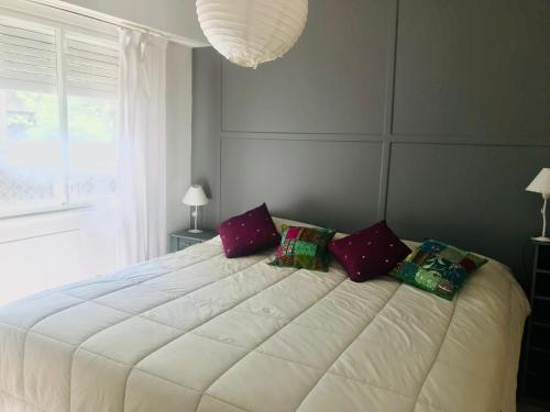 Un dormitorio con una gran cama blanca con almohadas. en Apartamento Segui UNICO LUMINOSO en Buenos Aires