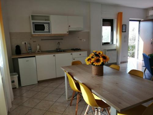 eine Küche mit einem Holztisch mit einer Blumenvase darauf in der Unterkunft B&B Ginevra in Gizzeria