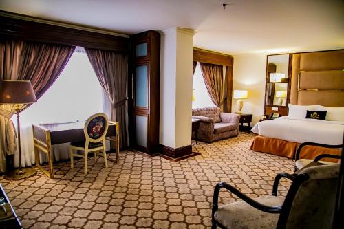 a hotel room with a bed and a desk at Saffron D'or Hotels in Lahore