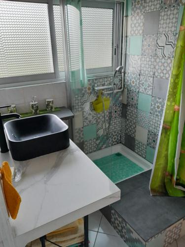 y baño con lavabo y ducha. en Auberge du Cap en Cilaos